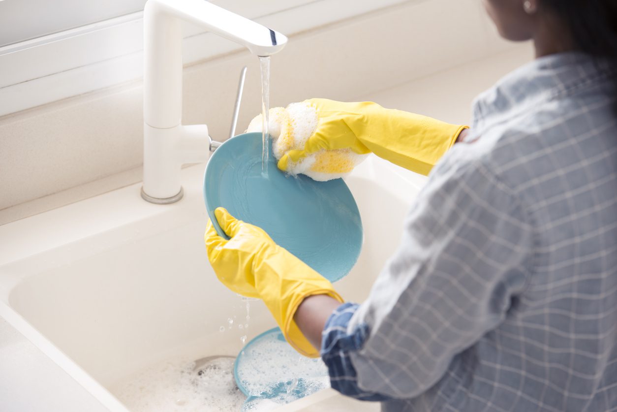 Sarı eldiven ile bulaşık yıkayan kadın
