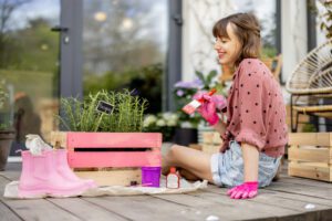 Woman painting wooden box, doing some renovating housework outdoors
